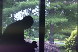 Mann betet vor Fenster