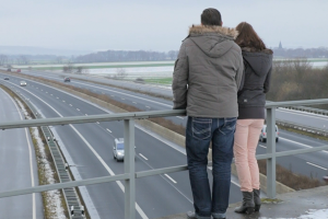 Ehepaar steht auf Autobahnbrücke