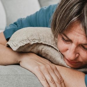 Frau liegt einsam auf der Couch