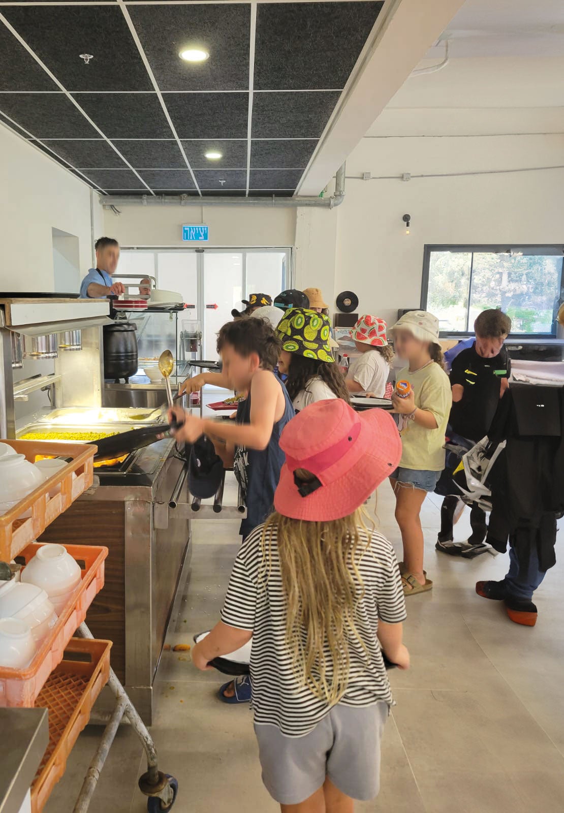 Eine Gruppe Kinder holt sich an der Theke Essen