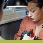 Ukrainische Frau arbeitet in ihrem Nagelstudio