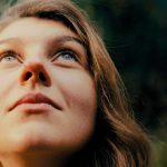 Frau schaut nach oben. Beitrag zum Thema Gottes Stimme hören.