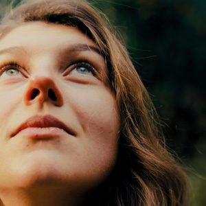 Frau schaut nach oben. Beitrag zum Thema Gottes Stimme hören.