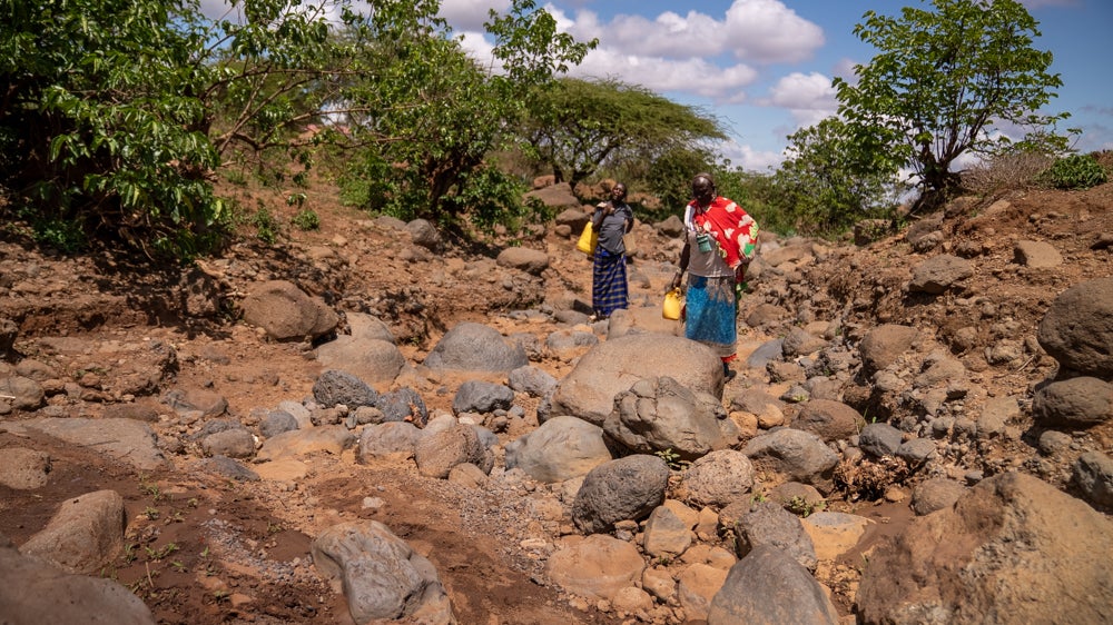 Lende und eine Nachbarin auf dem Weg zum Wasserholen.