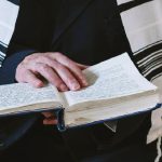 Jemand liest in der Bibel und hat eine israelische Flagge umgehängt