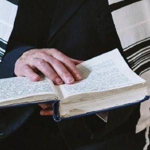 Jemand liest in der Bibel und hat eine israelische Flagge umgehängt