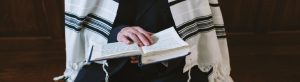 Jemand liest in der Bibel und hat eine israelische Flagge umgehängt