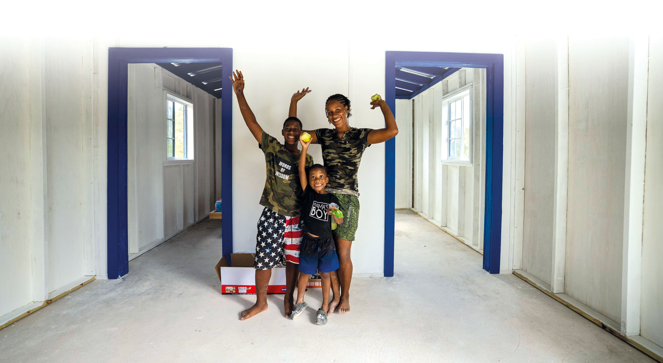 Mickella und ihre zwei Kinder stehen in ihrem neuen Haus auf Jamaika